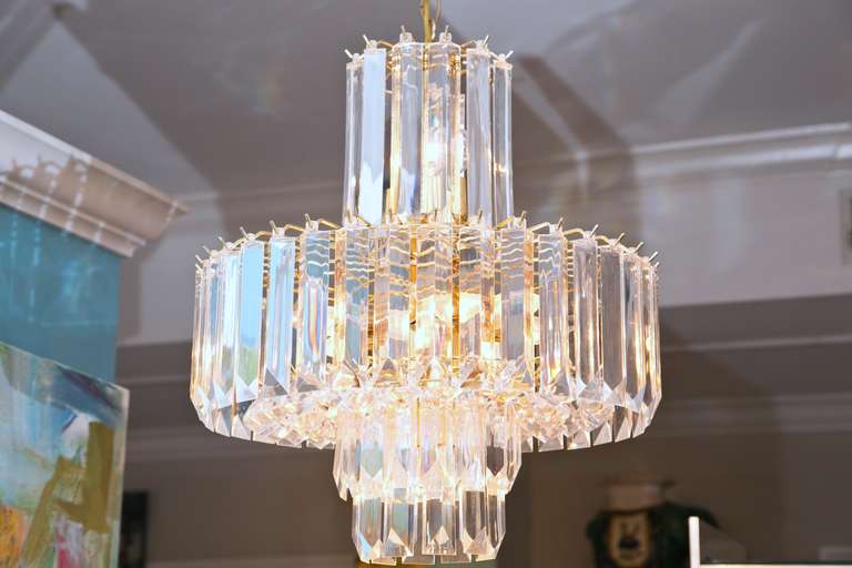 Mint condition, clear Lucite, 1970s chandelier in tier form. Long crystal-cut prisms on the outer surface with a double ring of faceted baubles when viewed from underneath (see photos at right). Outstanding piece of Mid-Century lighting.