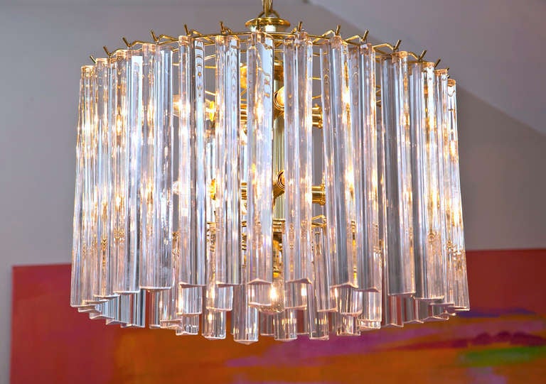 A very simple design with great impact. Double circle of mixed lucite and glass prisms hang fom a pristine brass inner frame. Nine bulbs and in great condition.
