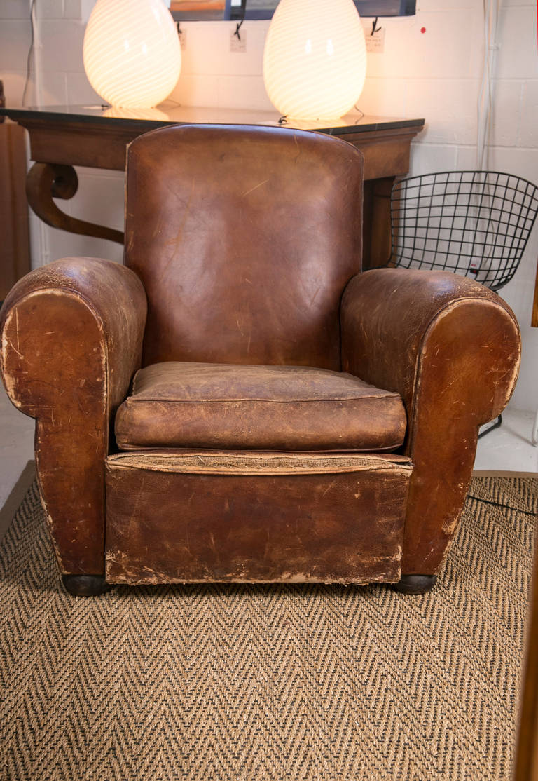 Very comfortable 1920s-1930s French leather club chair. Classic European Art Deco styling. Although there is much wear on this club chair, the frame is solid and the over-all feel is excellent.