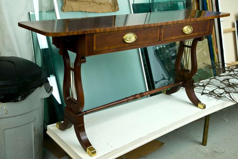 Classic vintage drop-leaf Baker Console in Banded Mahogany with Lyre-Motif supports and brass-cap foot. Measurement open is 58