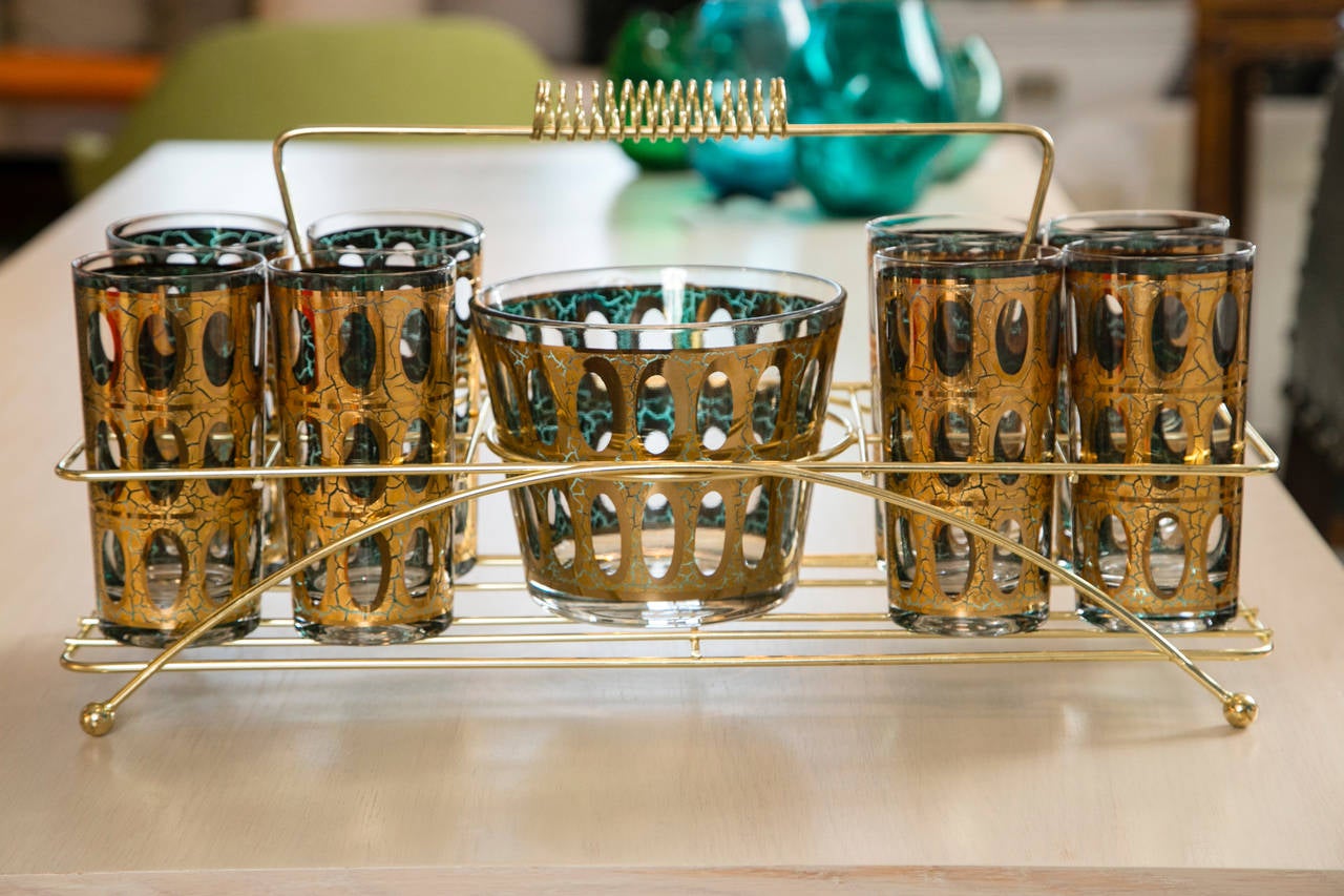 A 1960s set of eight gold foil oval cut hi ball glasses with matching ice bucket. The original Mad Men era set sits in a Space Age holder and the whole set is in great condition.