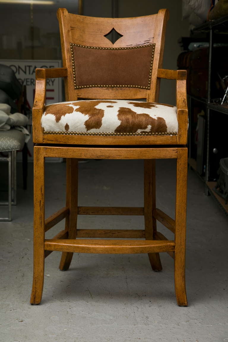 Very solidly crafted set of 6 elm wood swivel stools with custom cow hide seats, padded leather back-cushion, diamond cut-out back panel, and nailhead trim. Very high quality manufacture in the manner of Guy Chaddock.