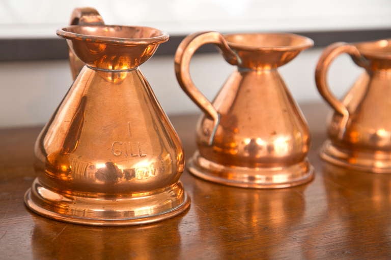 Fine set of 9 solid copper measuring pitchers. Engraving on each depicts measurements from 1 gallon to 1/8 gallon.Heights range from 3