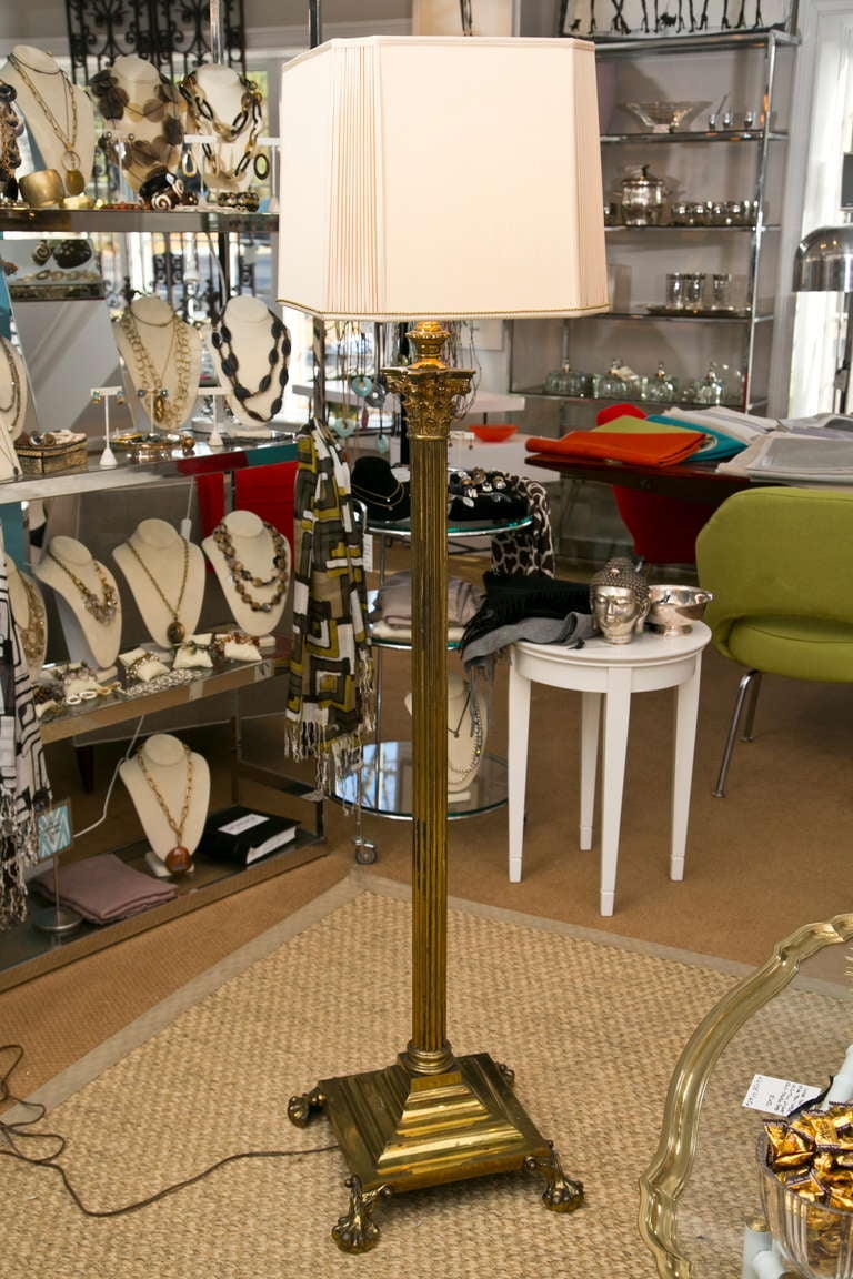 An impressive solidly cast brass floor lamp in a fully realized Corinthian Column form. Good, solid weight with pronounced ball and claw foot. Including octagonal custom shade.