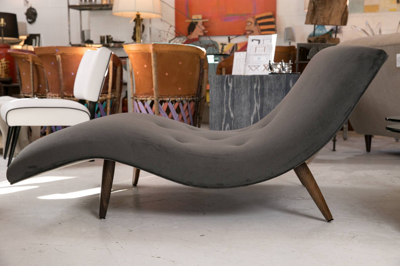 Iconic Mid-Century design by one of the truly inventive creators, Adrian Pearsall. Delicate yet strong tapered wood legs support a wavy chaise that is generously proportioned to hold two. Meticulously tailored and custom upholstered in a rich,