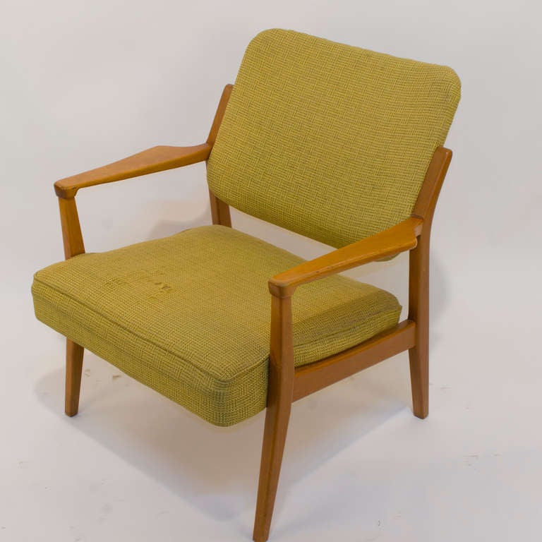 A comfortable chair crafted of solid teak and still wearing its original green tweed upholstery. This chair was most likely part of an office suite for entertaining, mad men style. Easily moved from place to place, the chair can be pressed into