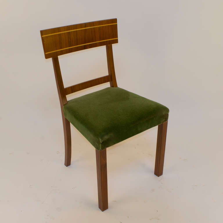 Clean design lines of the Art Deco movement are embodied, with the thin golden birch veneer banding set into walnut enhancing the effect. The olive green velvet upholstery beautifully adds subtle depth and texture.