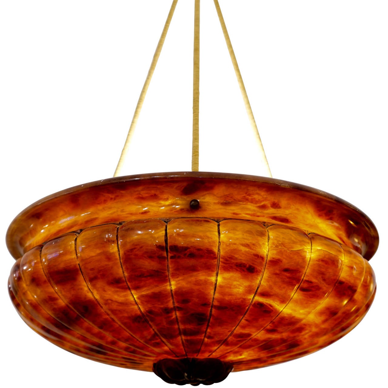 This dramatic amber fixture is a show stopper.  With a deep amber background, fossilized minerals in brown and green streak back and forth across the detailed carvings.  Best mounted with three 75 watt bulbs on a dimmer circuit to show off the