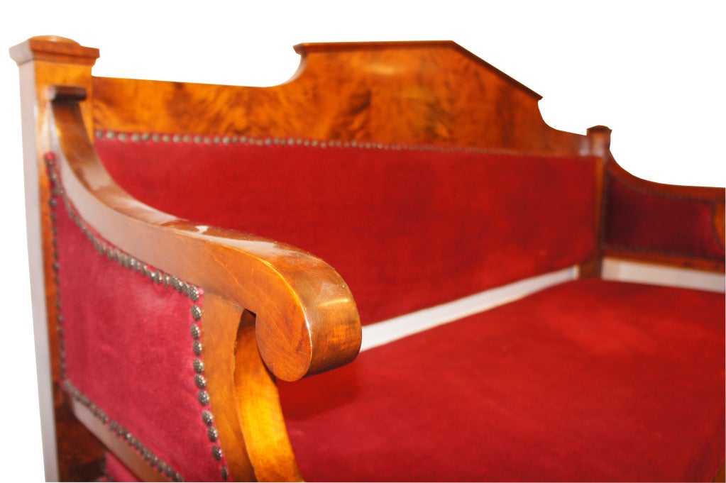 Ein formelles Sofa mit drei bequemen Sitzplätzen, geschwungenen Armlehnen und einer leicht geschwungenen Rückenlehne mit Giebeldach.