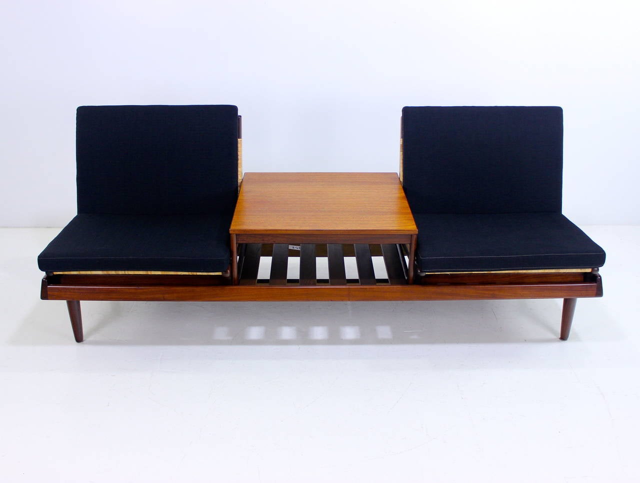 Danish modern modular seating group designed by Hans Olsen, model TV161.
Bramin, maker.
Rich teak and caning with steel and oak bracing for timeless style and durability.
Two stand alone caned chairs and one table measuring 24