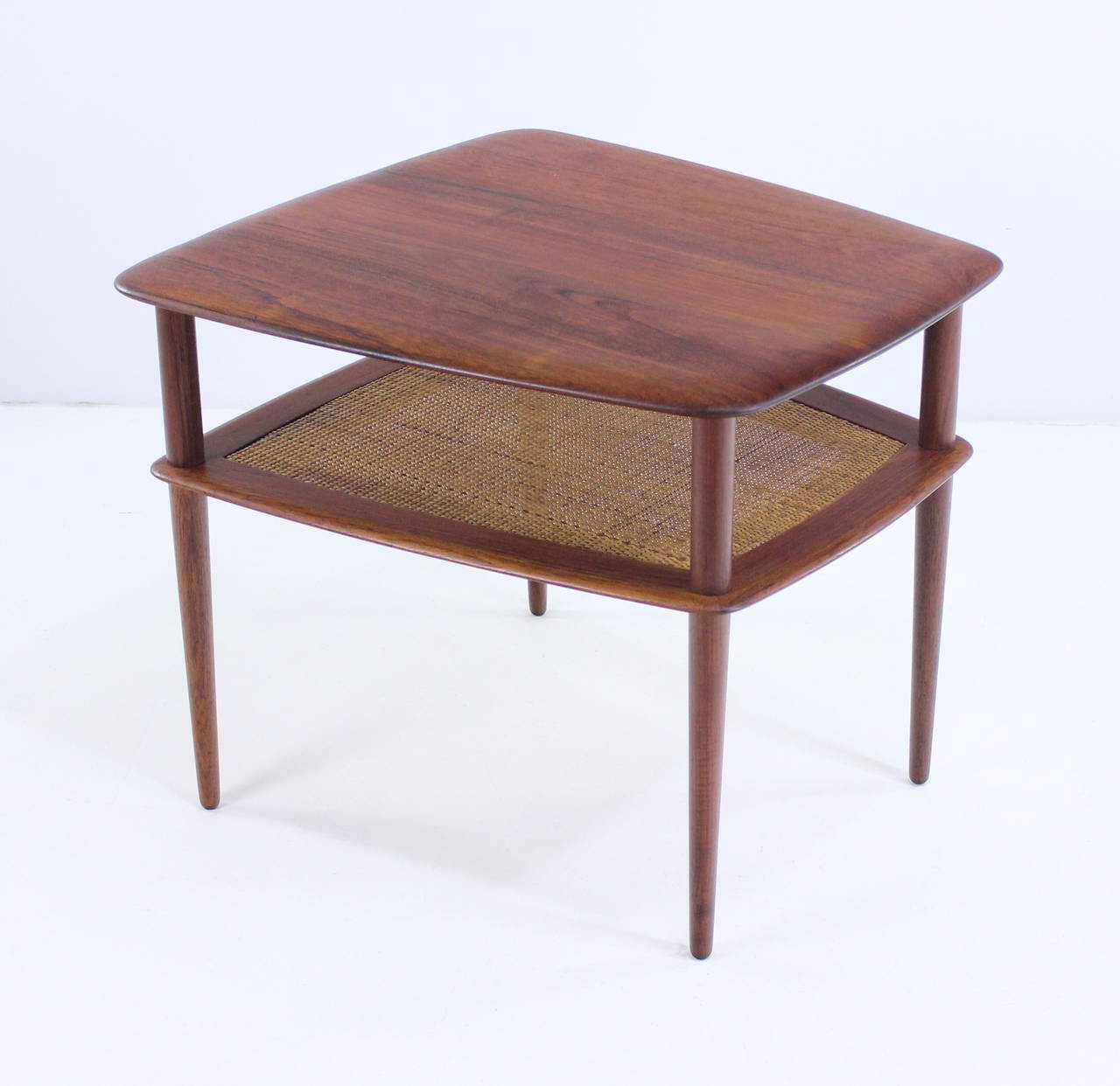 Danish modern end or side table designed by Peter Hvidt.
France and Daverkosen, maker.
Richly grained solid teak. Lower caned magazine or book shelf.
Rare larger size.
Professionally restored and refinished by LookModern.
Matchless quality and