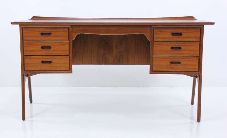 Danish modern desk designed by Svend & Madsen.
Richly grained teak. A-frame base.
Three drawers on each side. Bookcase front with signature Madsen shark fin edge on desk top.
Stunning from every angle.
Professionally restored and refinished by
