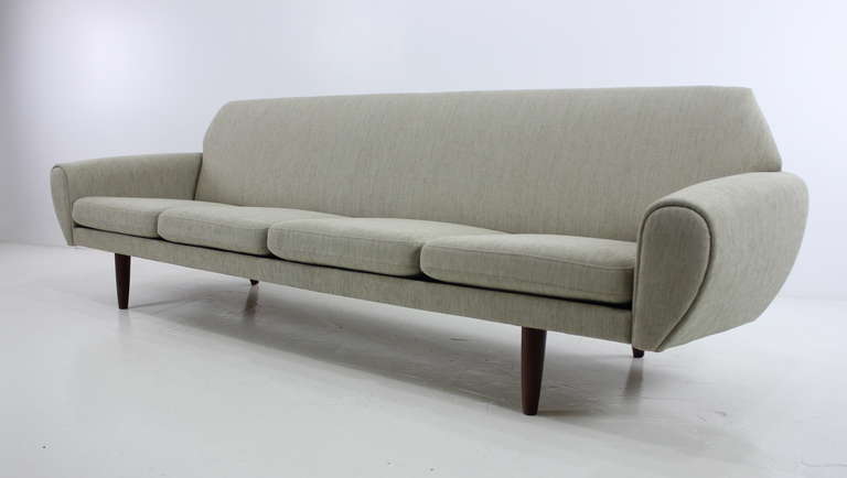 Long, low, Danish Modern four-place sofa designed by Johannes Andersen, styled with detailed precision and beauty.
Original metal inner spring cushions, teak legs.
Impeccably upholstered in highest quality period fabric. 
Professionally restored