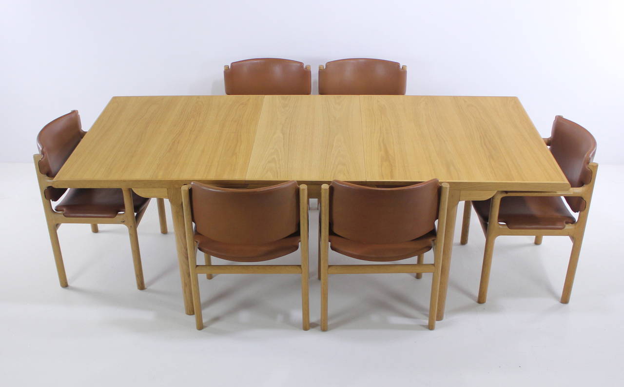 Impressive Danish modern dining set designed by Søren Willadsen.
Solid, stately craftsmanship and style.
Rich light golden oak.
One leaf, which stores under table, measures 87" fully extended.
Six chairs, with original terra cotta leather