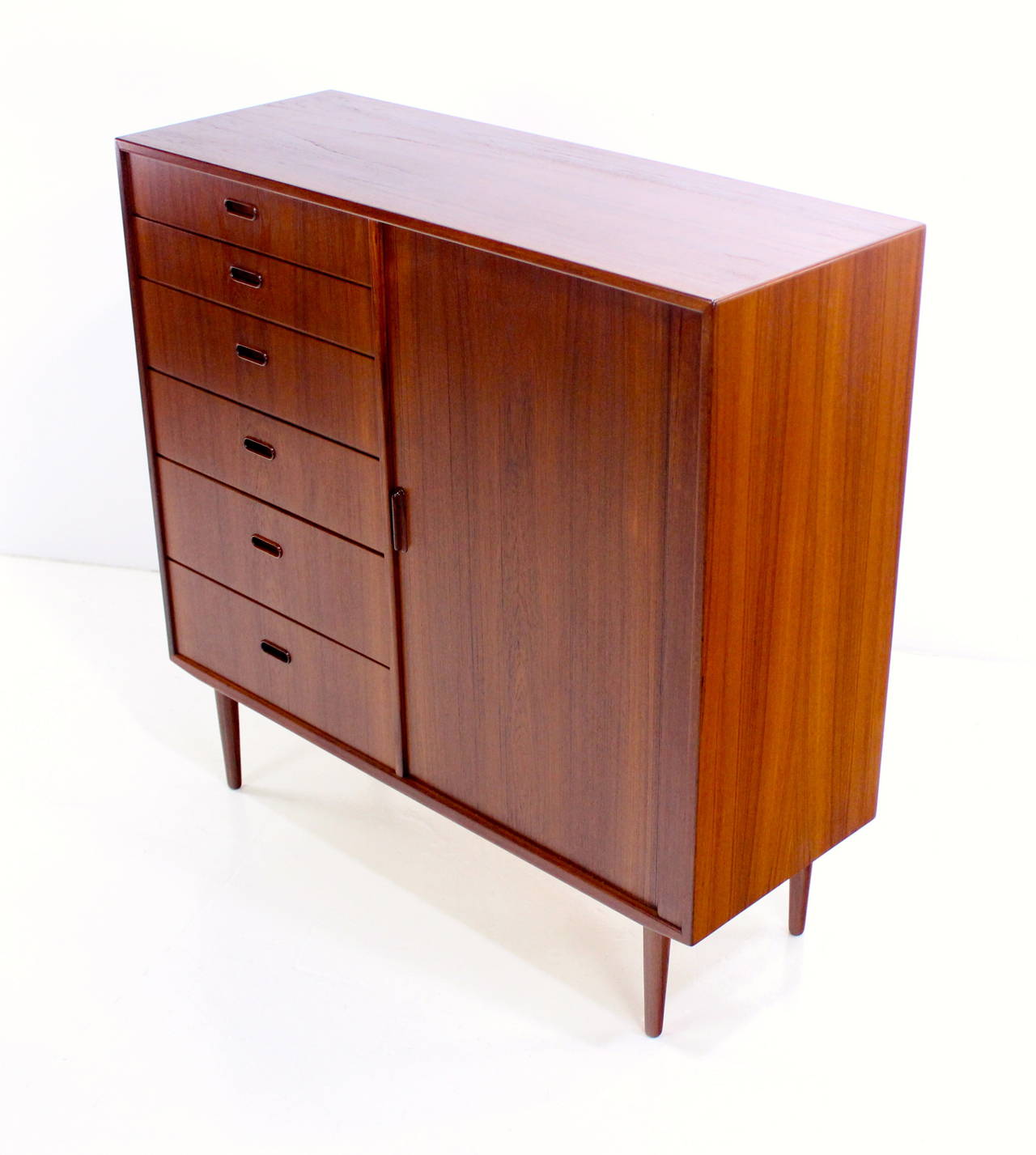 Danish modern gentleman's chest designed by Ib Kofod-Larsen.
Richly grained teak with birch interior.
Beautifully crafted tambour door on right glides open to six pull-out trays.
Six drawers on the left.
Spacious storage for the most discerning