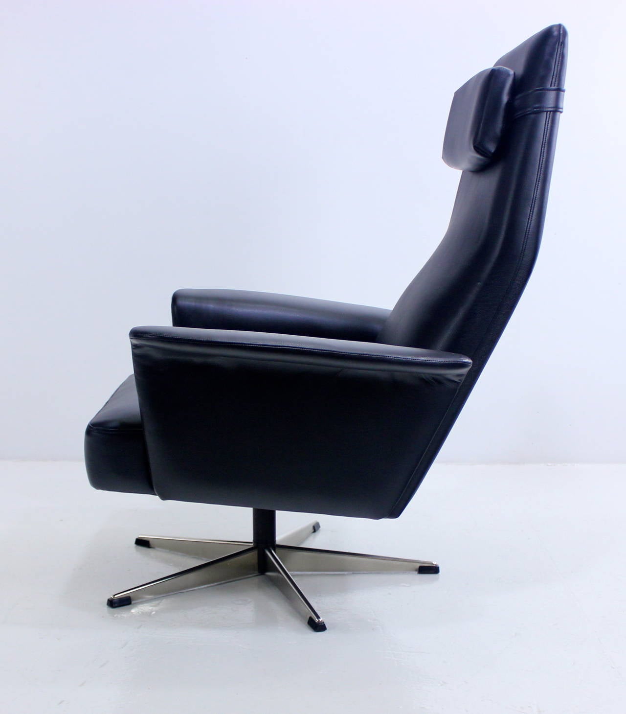 Impressive Danish modern power chair.
Swivels 360 degrees on polished steel base.
New foam throughout provides superior comfort.
Newly upholstered in highest quality black leather, like vinyl.
Detachable pillow.
Professionally restored and