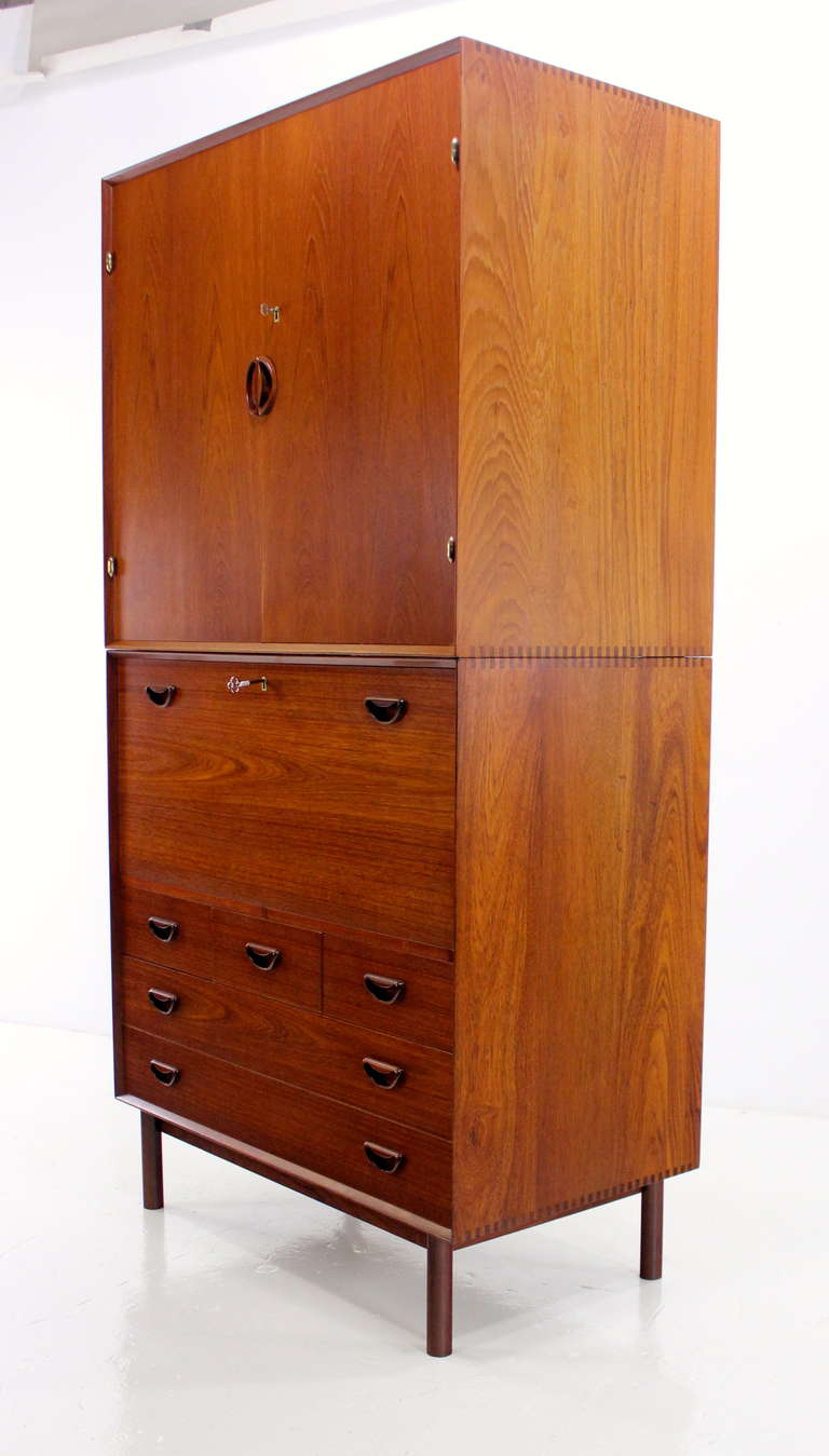 Danish modern, multifunction cabinet designed by Peter Hvidt.  
Povl Dineson, maker.
Features solid teak top and bottom units. 
Extraordinary craftsmanship and joinery.
Top has three removable drawers and shelving.
Bottom has locking drop down