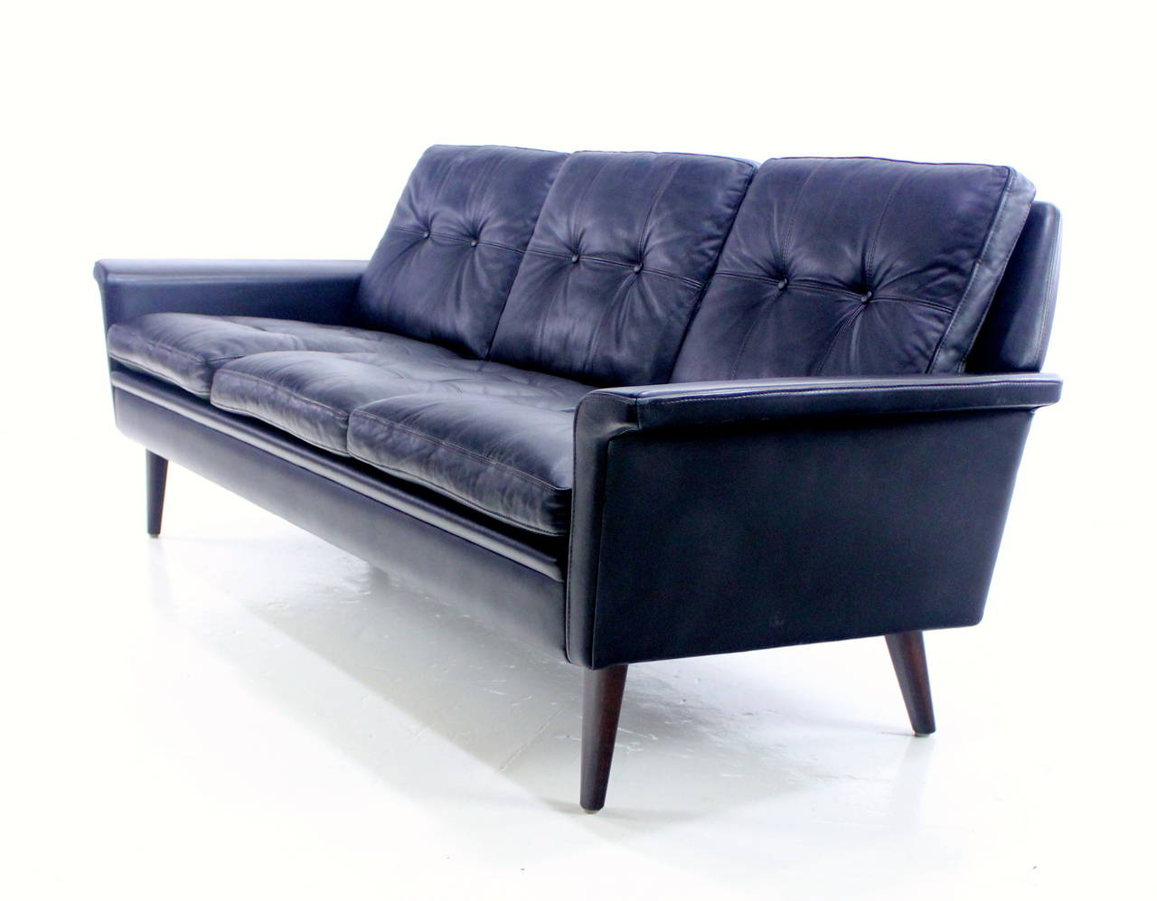 Classic danish modern three-place sofa.
Original black leather upholstery. Rosewood legs.
Built for maximum comfort and style.
Professionally restored and refinished by LookModern.
Matchless quality and price.
Low freight and quick ship.