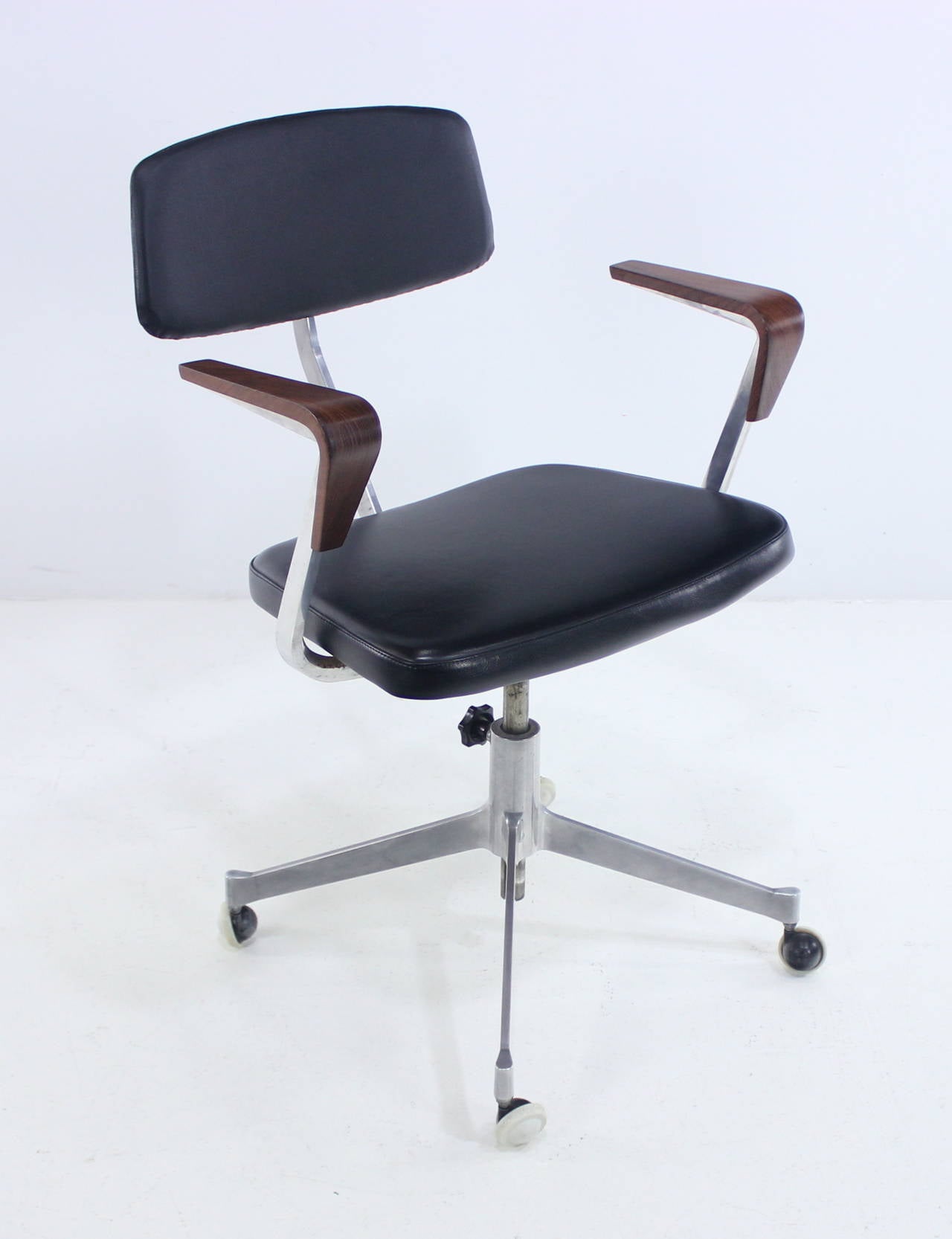 Extraordinary Danish modern office chair manufactured by Cardinal.
Aluminum base with original wheels.
Sculptural teak armrests.
Chair swivels, height adjusts, back tilts.
Original black vinyl upholstery.
Matchless quality and price.
Low