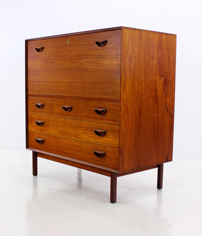 Danish modern secretary designed by Peter Hvidt.
Solid teak with extraordinary craftsmanship and joinery, Peter Hvidt trademarks.
Top has locking, drop down writing surface with three divided drawers inside.
Three small drawers and two large