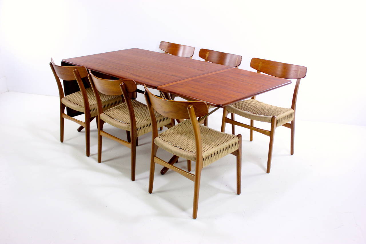 Danish modern dining set designed by Hans Wegner.
Andreas Tuck, table maker. Model AT 304.
Carl Hansen, chair maker.
Six chairs with teak backs, oak frames and new cord seats measure 19