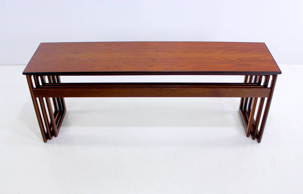 Set of three rare Danish Modern nesting tables. Raymor, maker.
Long and lean with square shaped legs and a stretcher on one side.
Rich teak top with mahogany edge. Oak base.
Small table measures 45.74