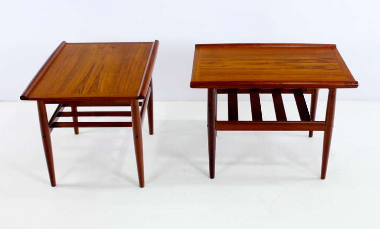 Set to two danish modern end tables designed by Grete Jalk in 1960.
Poul Jeppesen, maker.
Richly grained teak with curved edges on top, lower slated magazine shelf.
Professionally restored and refinished by LookModern.
Matchless quality and