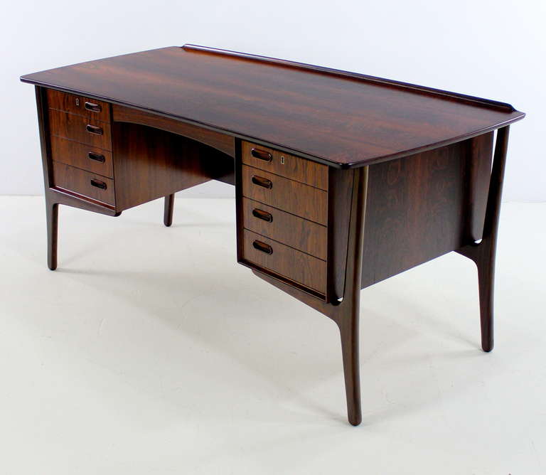Danish modern desk designed by Svend Madsen with extraordinary finesse and flair.
Richly grained rosewood with extraordinary graining. Slightly curved top, front and back, with signature Madsen lip on front edge.
Four drawers on each side, top two