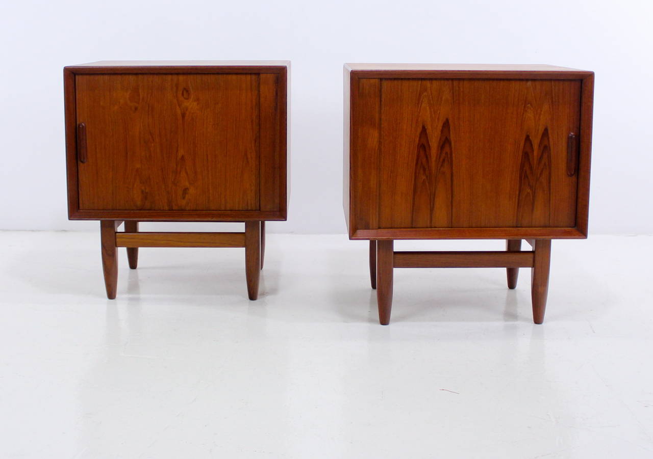 Two matching Danish modern nightstands. Falster, maker.
Richly grained teak with birch interior.
Tambour doors glide open to slide out trays and adjustable shelves.
Framed front and sculptural door pulls add extra dimension.
Finished on the back