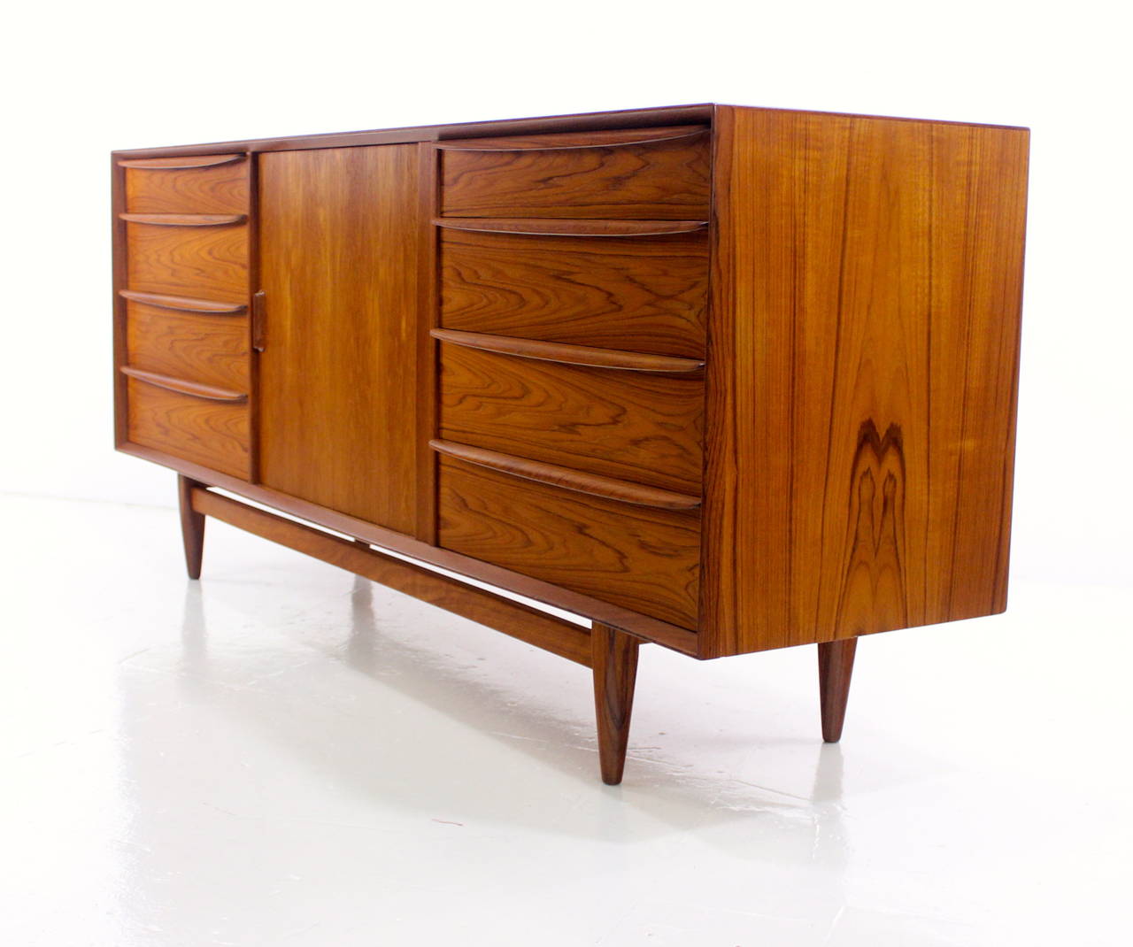 Danish modern dresser chest by Falster Møbelfabrik.
Richly grained teak with birch interior.
Tambour door in middle glides open to five drawers.
Four drawers, with sculptured handles, on each end.
Finished on the back for 360 degree