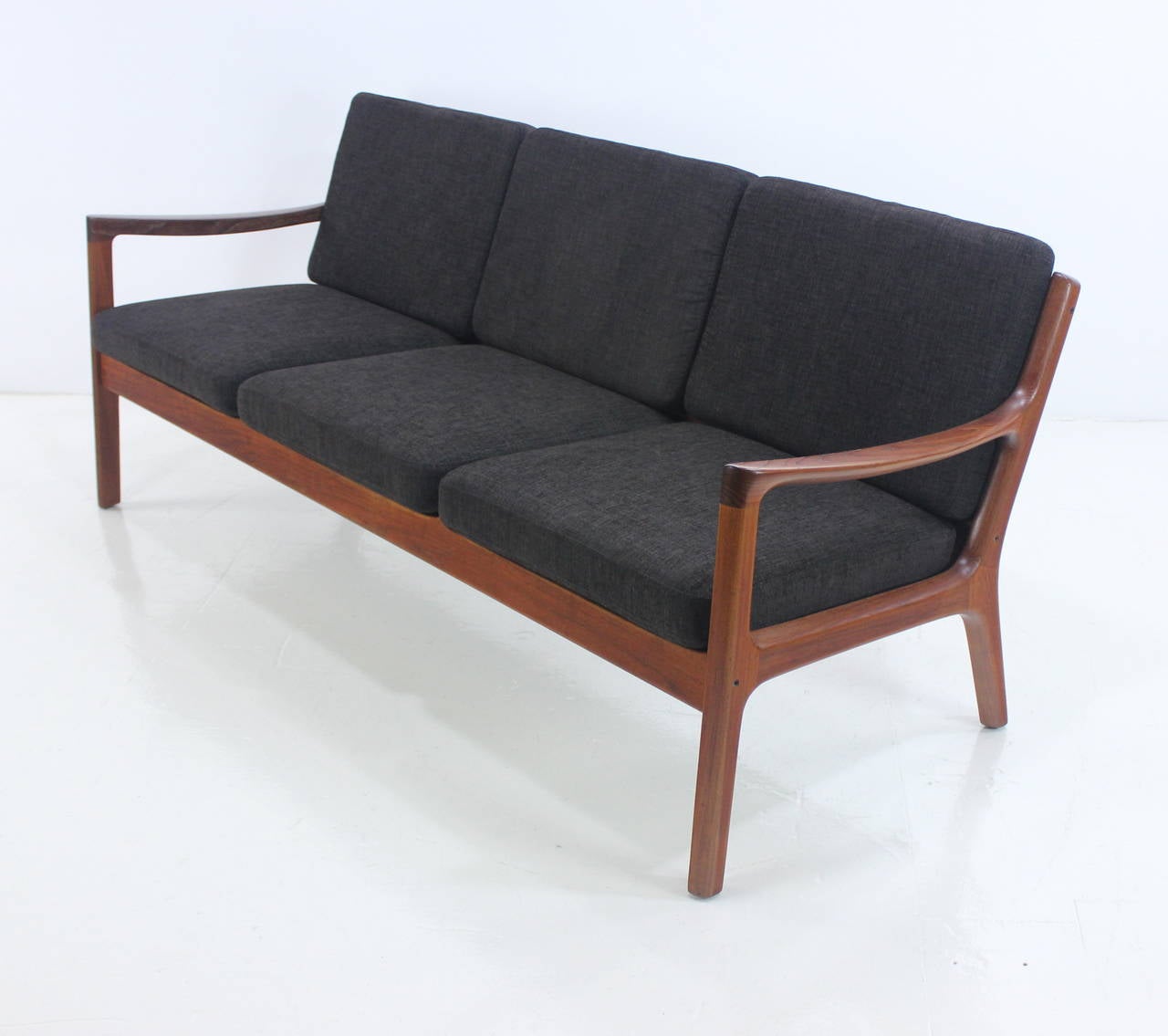 Danish modern sofa designed by Ole Wanscher.
Richly grained sculptural teak frame with exceptional joinery.
Extraordinary profile from every angle with dazzling back view.
Newly upholstered in highest quality burnished brown period