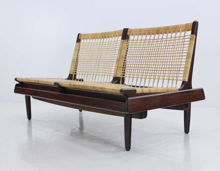 Danish  modern settee with minimalist Asian flair designed by Hans Olsen.  
Teak base and chair frames with perfectly woven cane seats and backs.  
Extraordinary modern form and function.
Professionally restored and refinished by LookModern. 