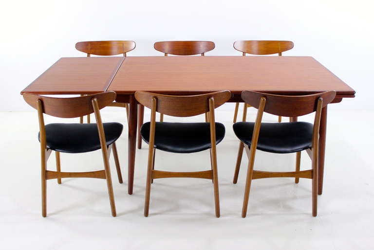 Danish modern dining set designed by Hans Wegner.  Andreas Tuck, table maker. Carl Hansen & Son, chair maker.  Gorgeous combination teak and oak draw leaf table, measures 94.5