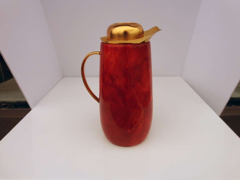 An Aldo Tura designed mercury glass lined carafe with wood shell wrapped in red parchment.  Worn label on underside