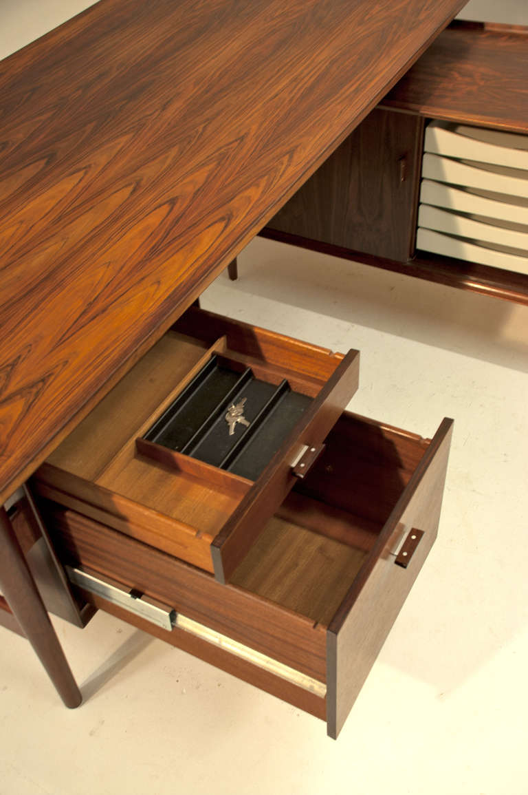 Iconic executive desk by famous Arne Vodder with the characteristic white drawers, detailed shaping and numerous bigger and larger shelves, compartments and drawers that all lock (all three original keys are there) 

Even the other accessories