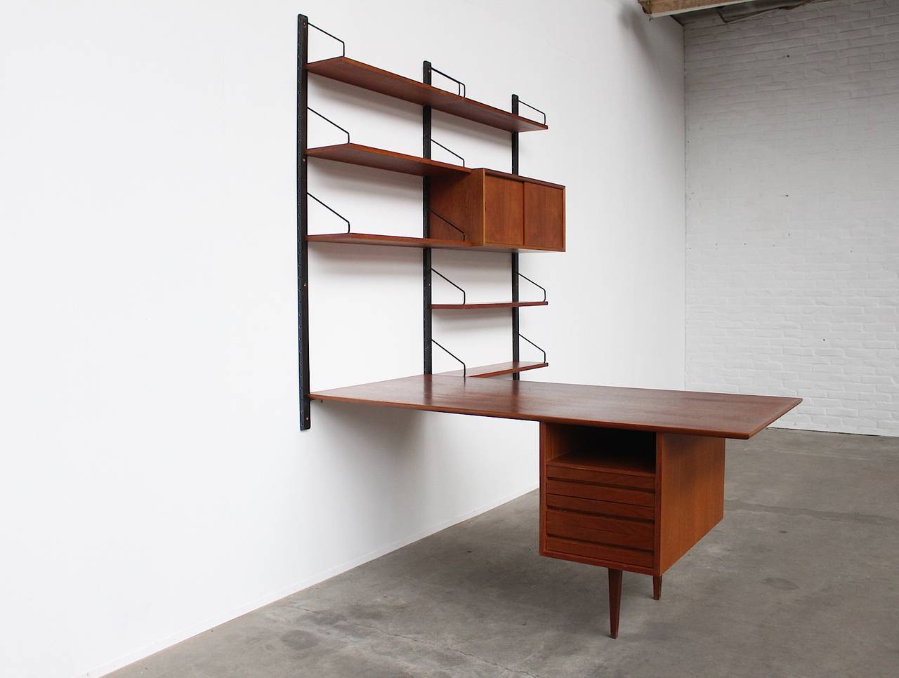 A beautiful wall-unit with an almost never seen rare desk element designed by Poul Cadovius.
Produced by Royal Systems Copenhagen, Denmark, 1960s.

A wonderful timeless design which is executed in a warm teakwood.
The system can be arranged by