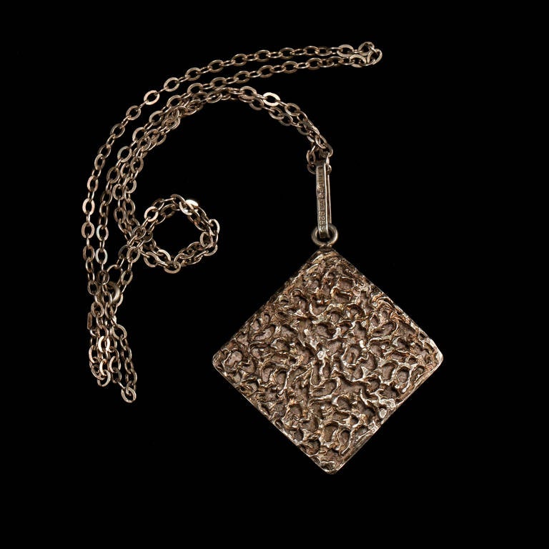 Sterling Silver, Bengt Hallberg, 1971,  Sweden
Weight 25 g 

Pendant with pierced decoration.
Height 7 cm, width 5 cm.
Chain in silver, length 58 cm.