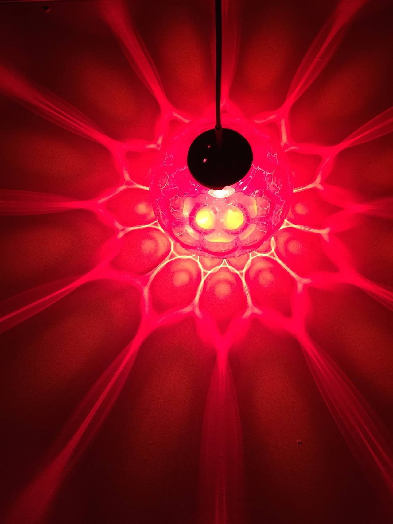 Ce pendentif en verre de cristal rouge de Carl Fagerlund pour Orrefors produit un effet étonnant dans l'obscurité

Le verre taillé à facettes distribue la lumière comme si votre chambre était remplie de rubis rouges étincelants

Le globe est