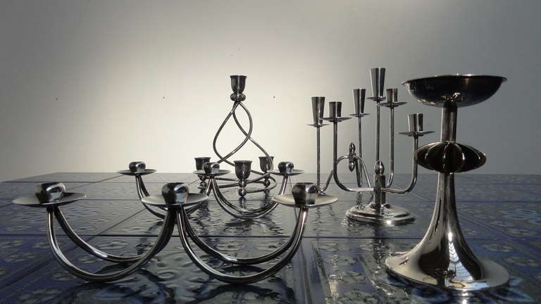 Collection of 6 silver plated Danish candle holders in the style of Hans Jensen. Some pieces are signed Silver Plated Berg Denmark and with a mark B90 and a soldier stamped in the piece.  Size mentioned is the largest of this collection.