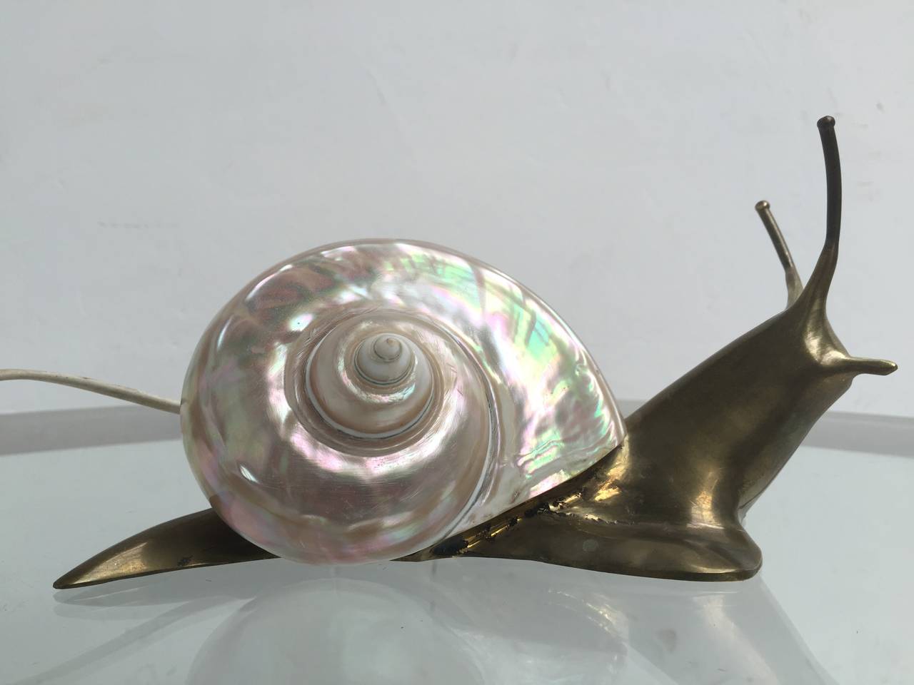 Truly beautiful  1950s French artist's  'escargot'  light sculpture made of cast bronze with a stunning handworked mother of pearl shell  serving as the light  diffuser.  

The snail form  has become somewhat of an icon in post war modern art from