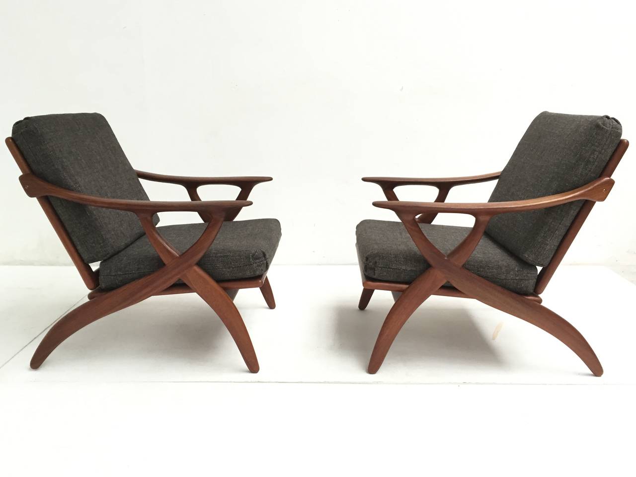 Pair of very elegant easy chairs with a beautiful biomorphic design.

Made of solid organic carved teak and new Ploeg upholstery in a wool, linen, cotton (34/34/29) fabric.

Very elegant, with highly architectural and sensual form.

The