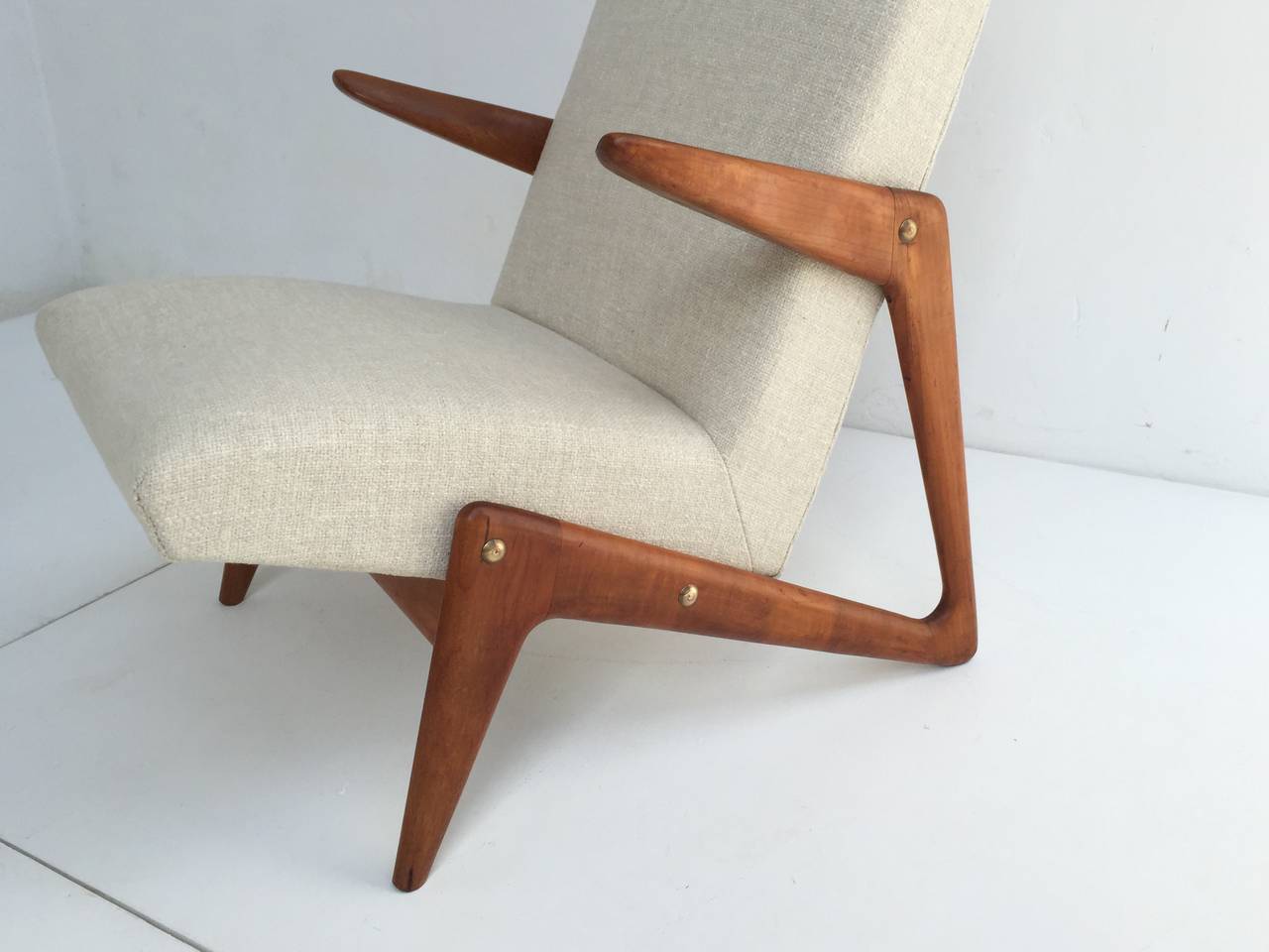 A stunning pair of early 1950s Belgian lounge chair with organic sculptural form carved walnut frame and brass hardware. 

This chair is often attributed to Belgian designer Alfred Hendrickx who was very inspired by the designs of Carlo Mollino