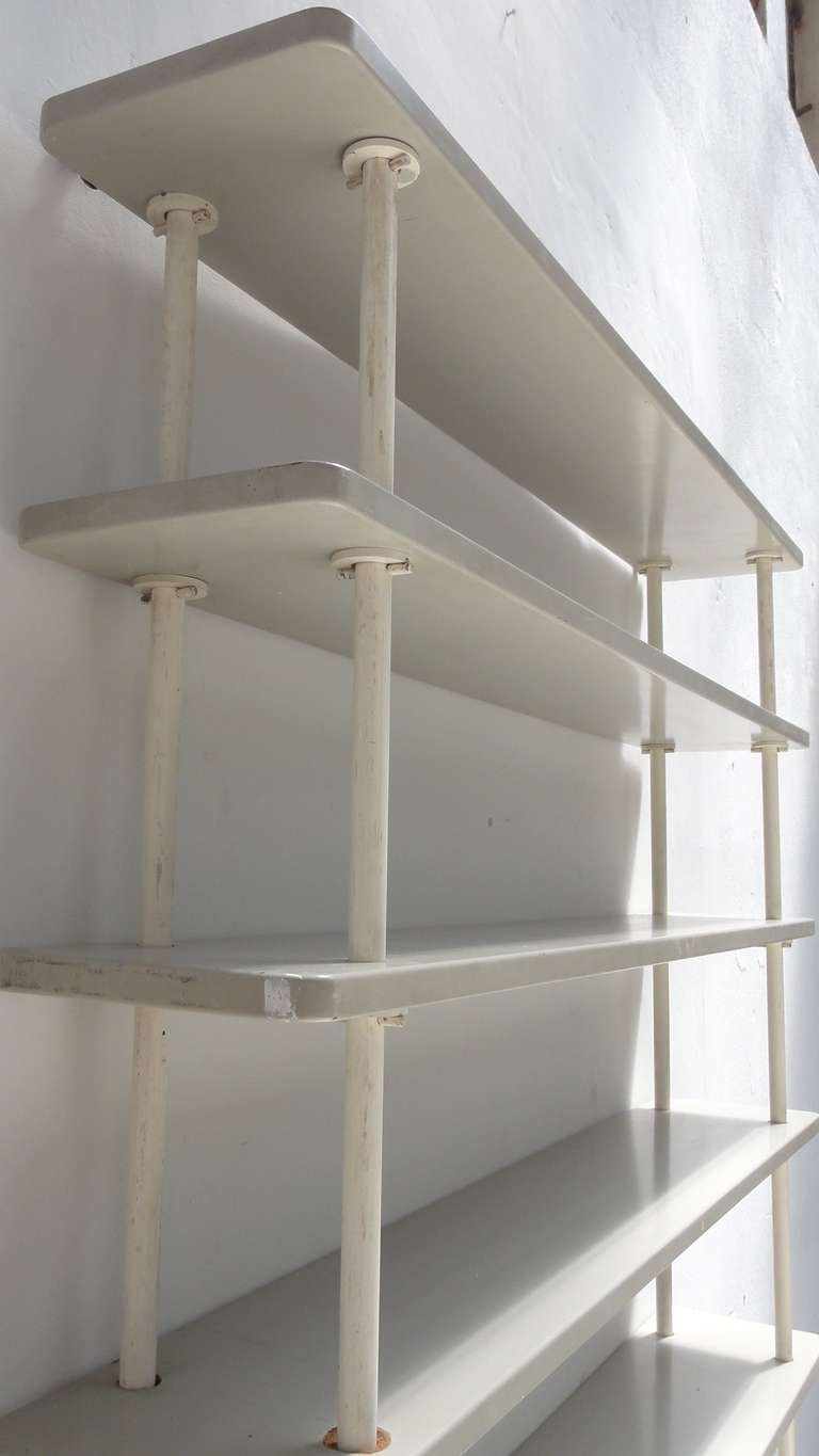 A rare find this 1930s Rietveld style shelving.

The 8 lacquered solid wooden shelves slide over 4 tubular metal uprights and are mounted by a simple (Rietveld like) construction.

When assembling this beautiful 'De Stijl' like shelving I
