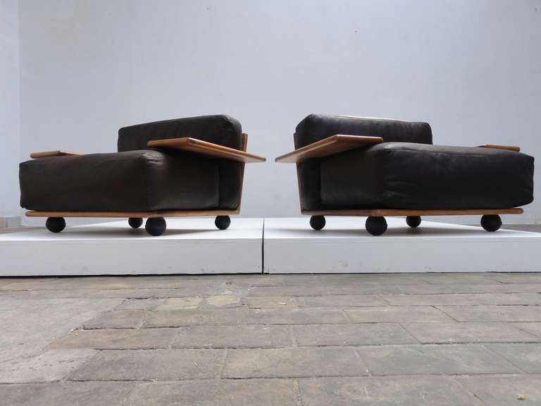 A beautiful and  rare  pair of Mario Bellini  'PIANURA', model 630, lounge chairs freshly reupholstered in dark brown leather with large  sculptural form armrests and frames made of solid italian walnut wood. These chairs were  produced by