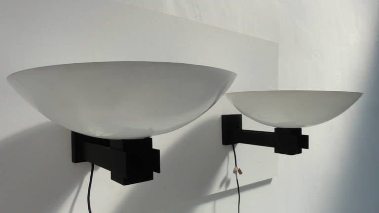 A nice minimal pair of uplight wall appliques by Raak lighting architecture Amsterdam

Black hardware and white dish shaped shades

Refurbished and rewired 

(we have an additional 4 pieces in stock in grey metal/white shade)