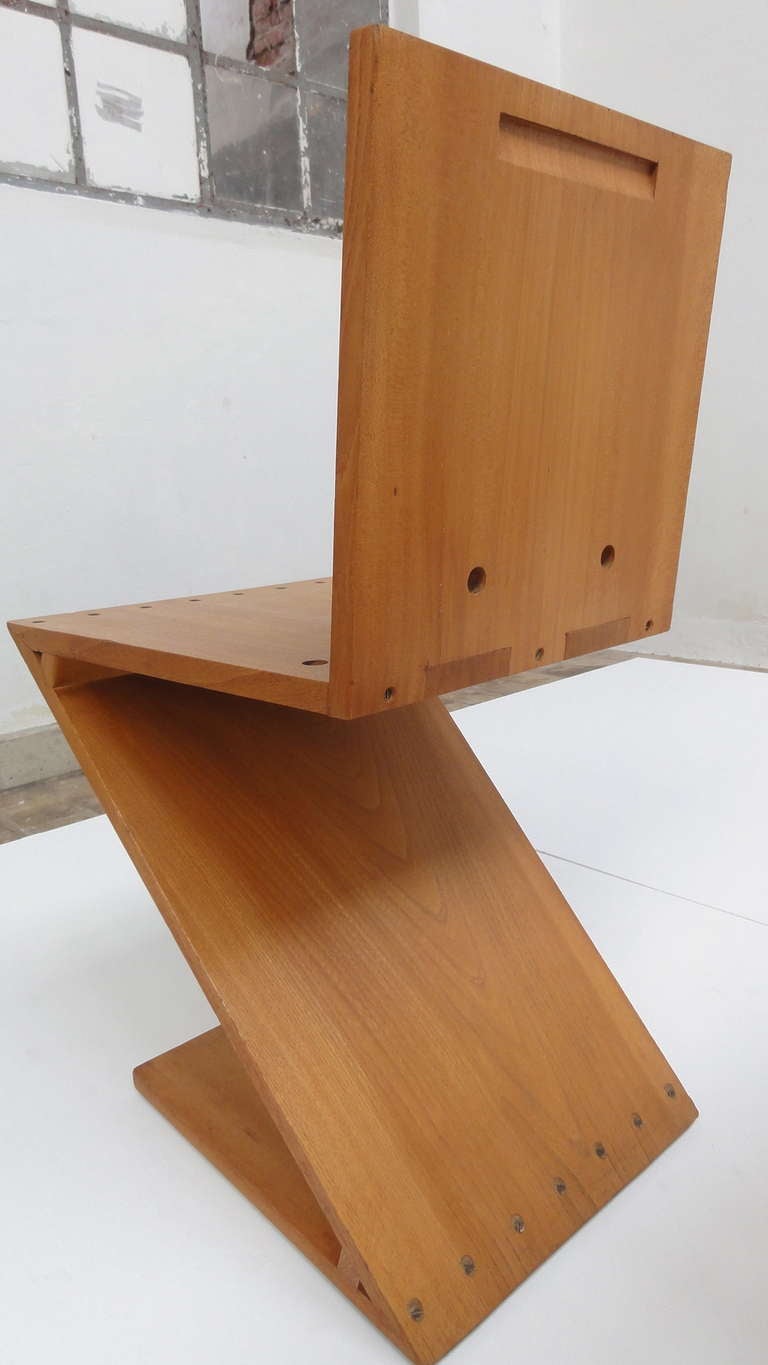 Pair of Gerrit Rietveld Zig-Zag chair produced by G.A. van de Groenekan, c. 1956.

The chairs have a five-dovetail seat and handle slot to back.
Made of solid Elm with brass nuts and bolds

One chair has a signature of G.A. van de Groenekan