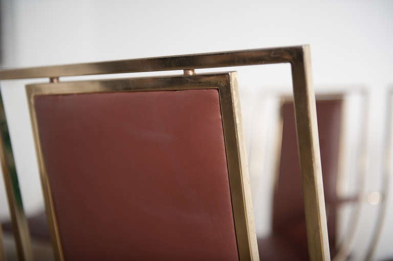 Exquisite and very rare set of eight sculptural  dining chairs by Renato Zevi finished in brass and cognac leather. 

Two of the chairs are carvers ie have armrests and the armrest height is  26 3/8