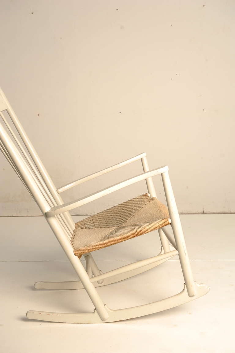 This is a very early Hans Wegner J16 Rocking chair produced by FDB Mobler in Denmark 3-1-1964 (impressed in wood underneath the arm)

The chair still has it's original white paint and Danish cord woven seat and is in a very nice used vintage