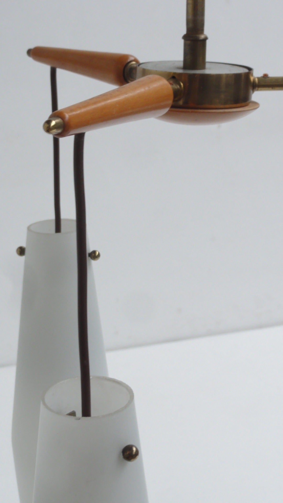 Un lampadario di produzione italiana di alta qualità con 3 pendenti in vetro che pendono da una struttura in ottone e betulla.

Una bella luce diffusa e un look minimal anni '50.