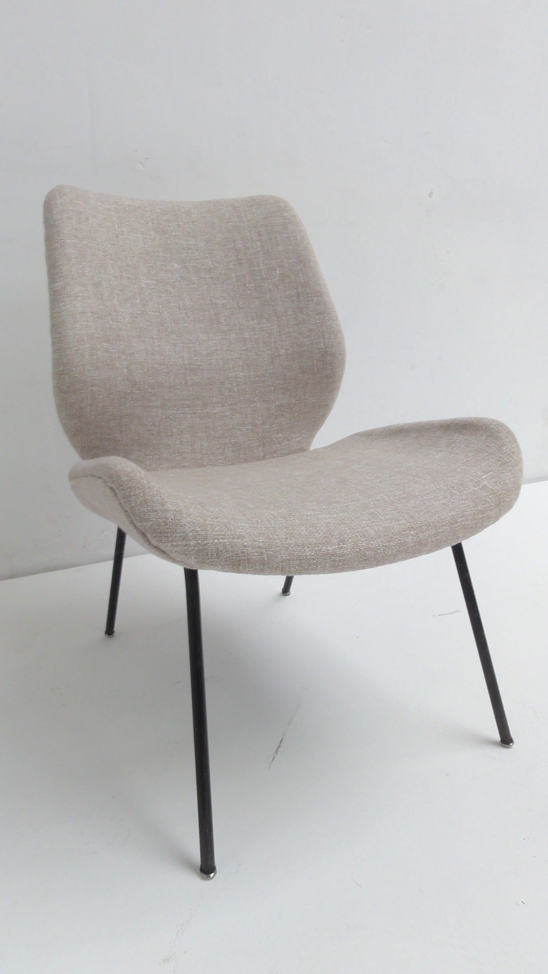 Elegant pair of 1950s Italian easy chairs attributed to Italian designer Gastone Rinaldi (1920-2006). Lovely subtle yet complex sculptural form finished in grey wool upholstery with typical Rinaldi style bent tubular form structure combined with